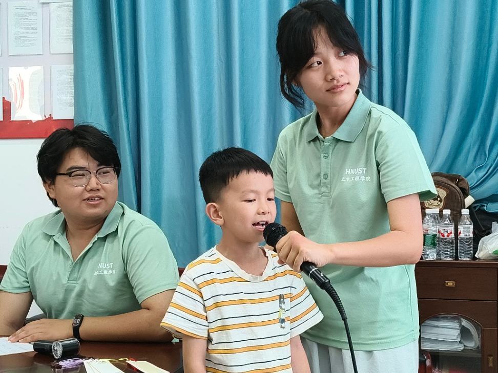 学生站在课堂中央手持话筒发言,在实践练习中锻炼当众表达能力