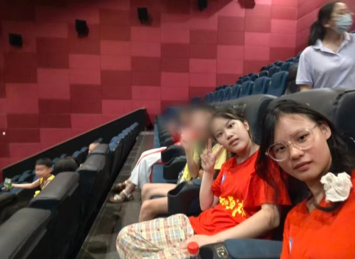 图为 志愿者与孩子们在电影院合影 (曾丹 供图)