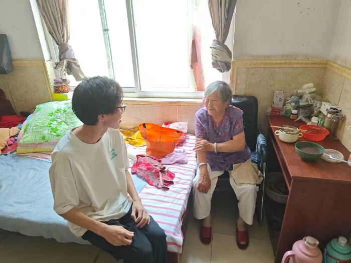 图为实践团成员在室内与老人谈心
